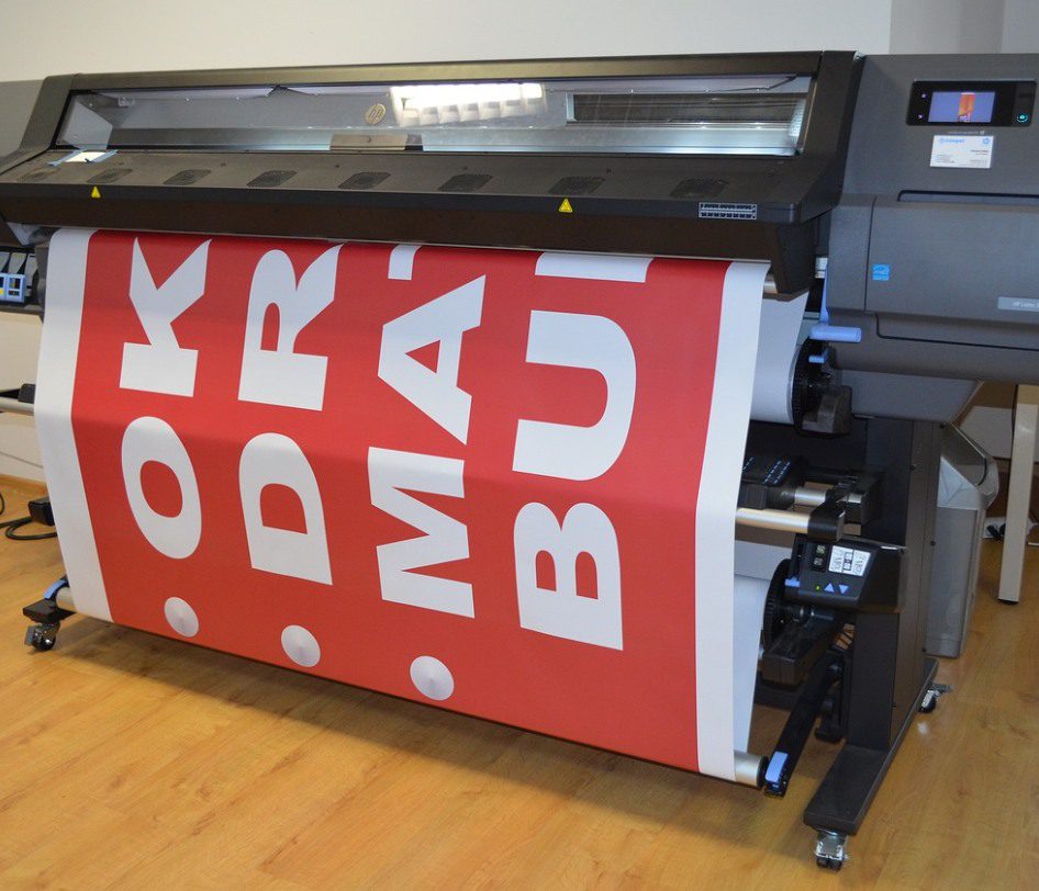 A large printer with a red banner on it.