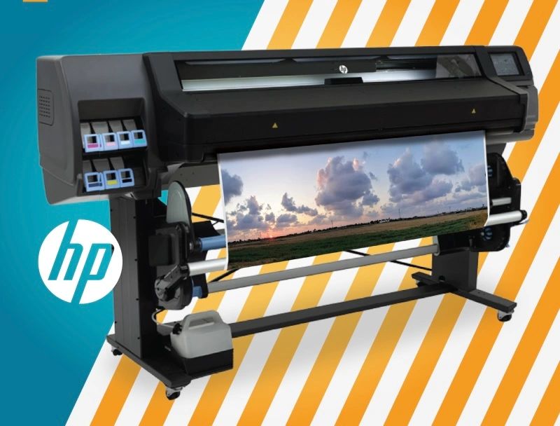 A large printer with an image of clouds on it.