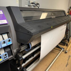 A large printer is sitting in the middle of a room.