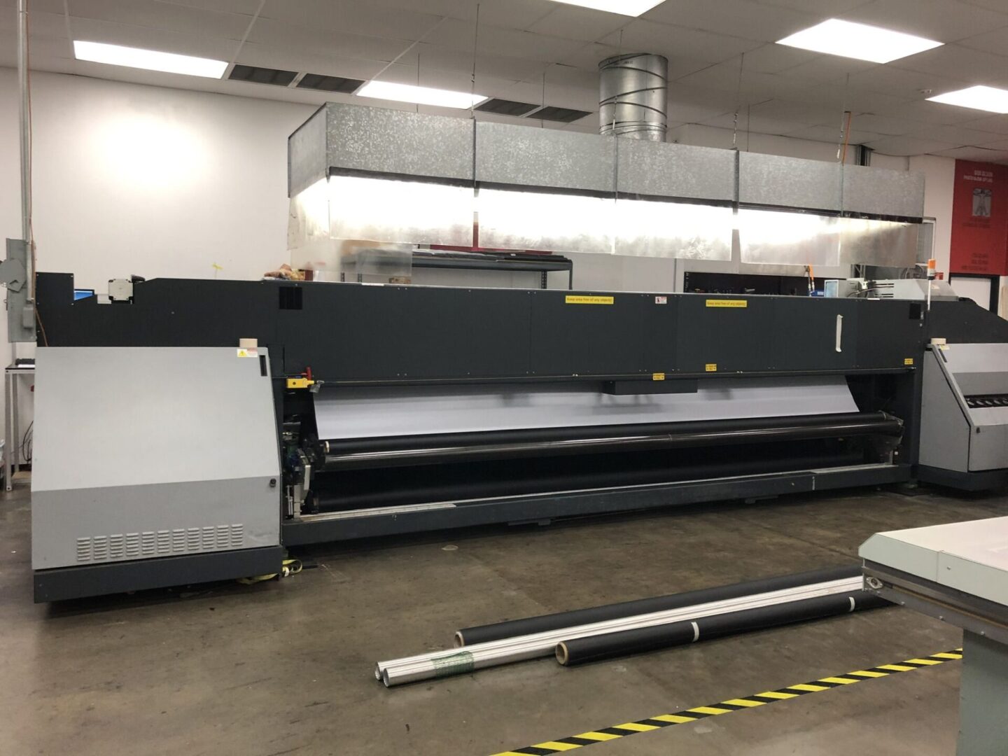 A large printer is sitting in the middle of an assembly line.