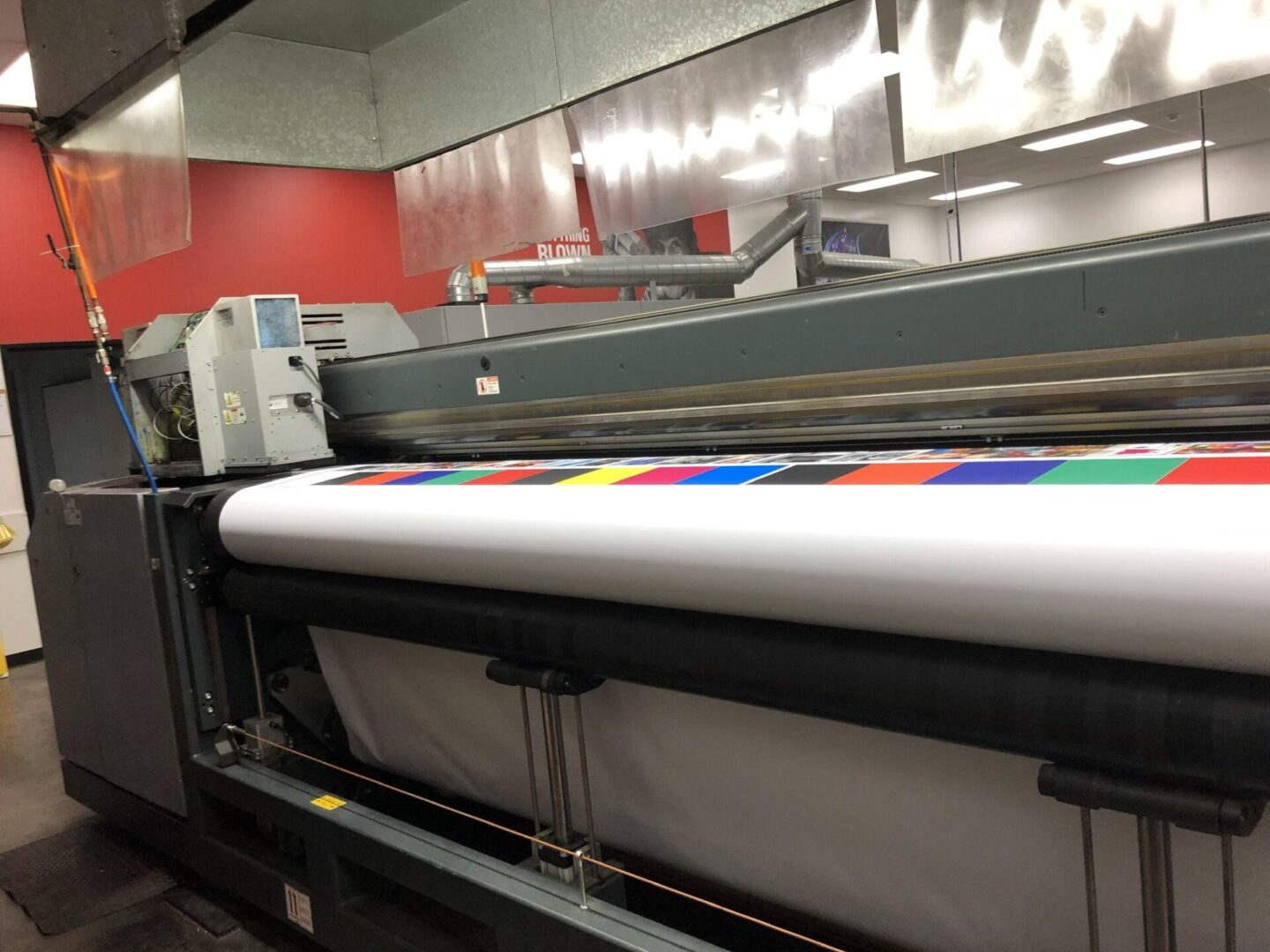 A large printer with colorful stickers on it.